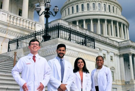 Practitioners, residents, fellows, and postgraduate students standing in front of the U.S. Capitol building